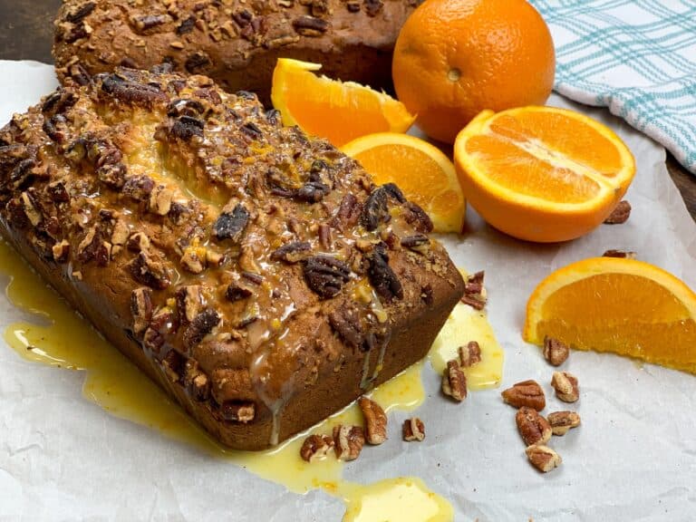 Banana nut bread with oranges on a counter