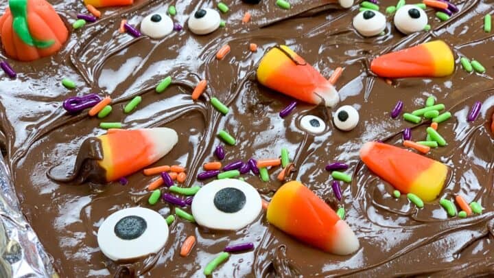 Halloween candy sprinkled on top of chocolate, toffee, and crackers