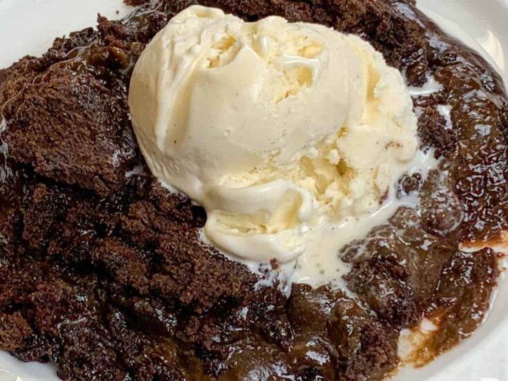 The best chocolate cake on a white plate with vanilla ice cream