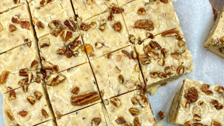 Butter pecan fudge cut into pieces on parchment paper.