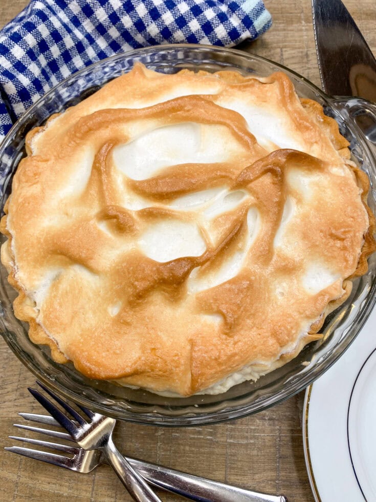 Chocolate pie with meringue in a pie dish sitting on the counter 