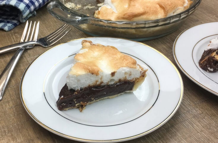 A slice of chocolate pie with meringue on a white plate. 