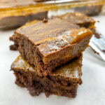 Pumpkin brownies stacked oh top of each other.