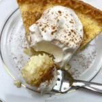 A slice of egg custard pie on a white plate.