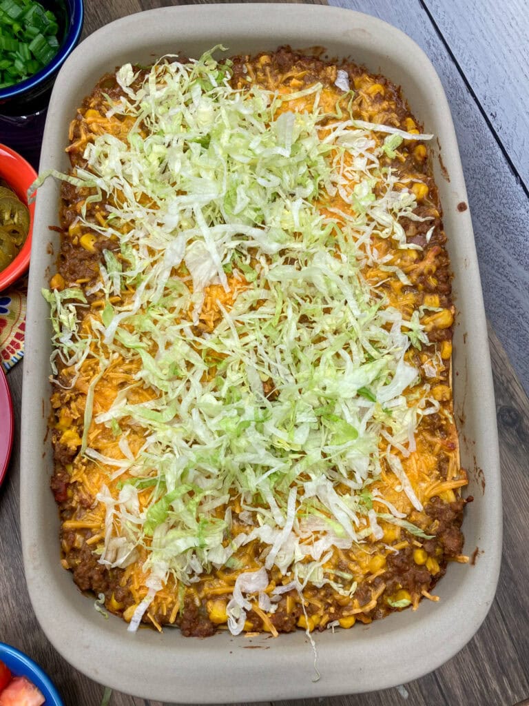 Topping the casserole with shredded iceberg lettuce