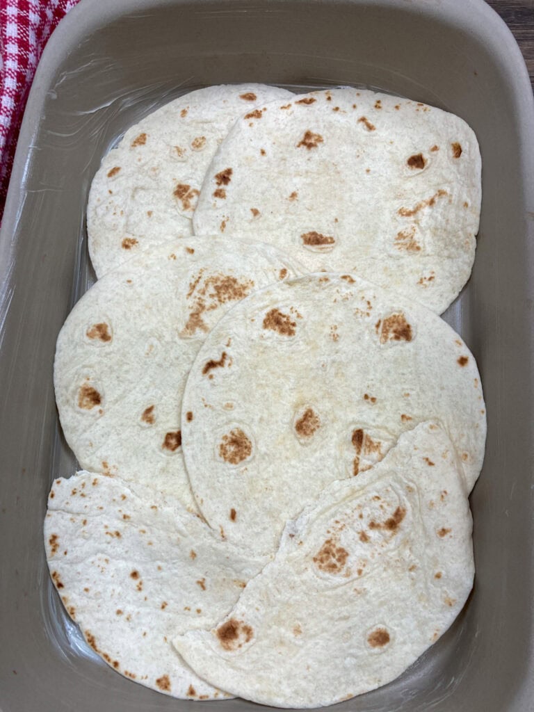 Lining a pan with tortillas