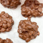 Rows of peanut clusters on white parchment paper.