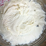 White frosting in a clear glass bowl.