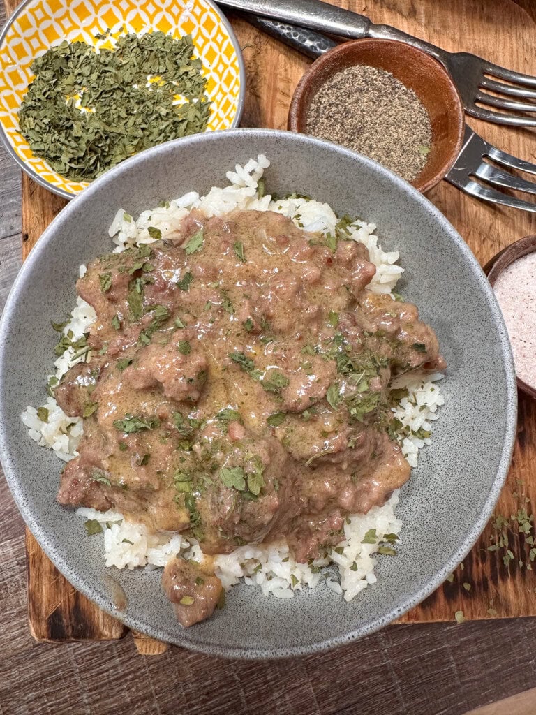 Slow cooker ground beef on top of rice in a bowl.