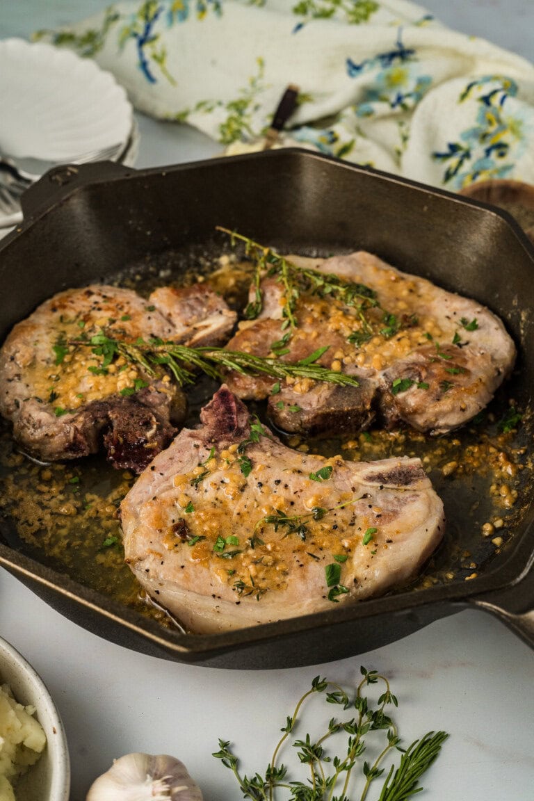 Garlic butter pork chops in a skillet.